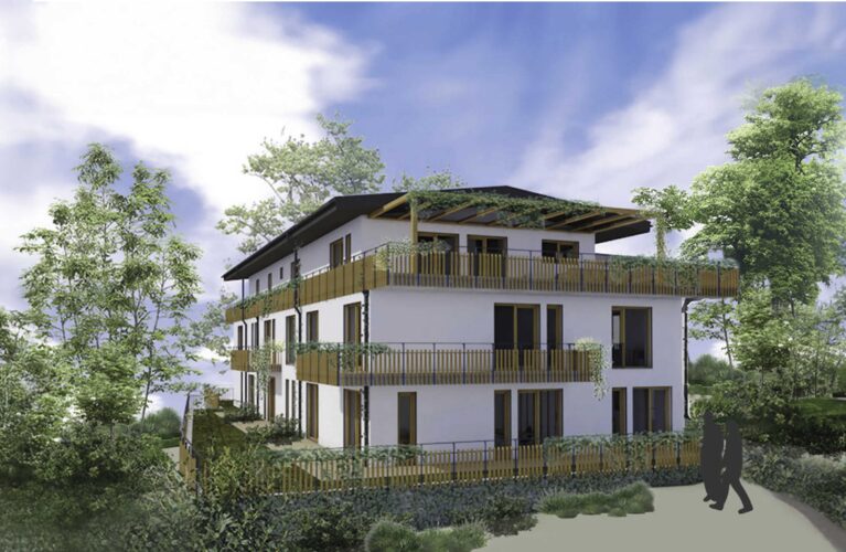 Mehrfamilienwohnhaus in Burgstetten mit moderner Architektur, begrünter Dachfläche, großen Balkonen und ruhiger Fassadengestaltung inmitten einer grünen Umgebung.